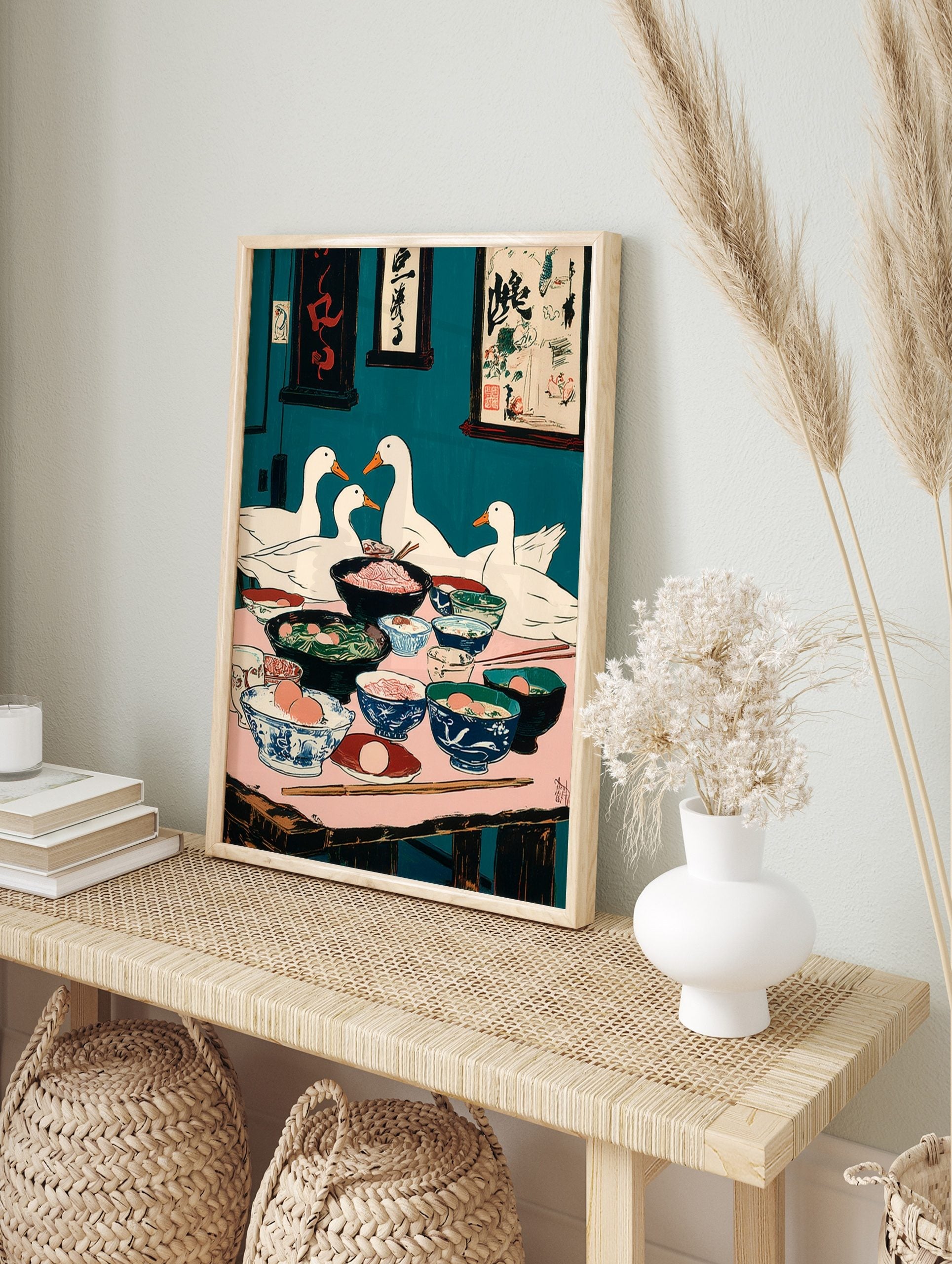 Illustrative print of four white ducks dining at a table filled with food bowls, teal, in an alternate framed mockup