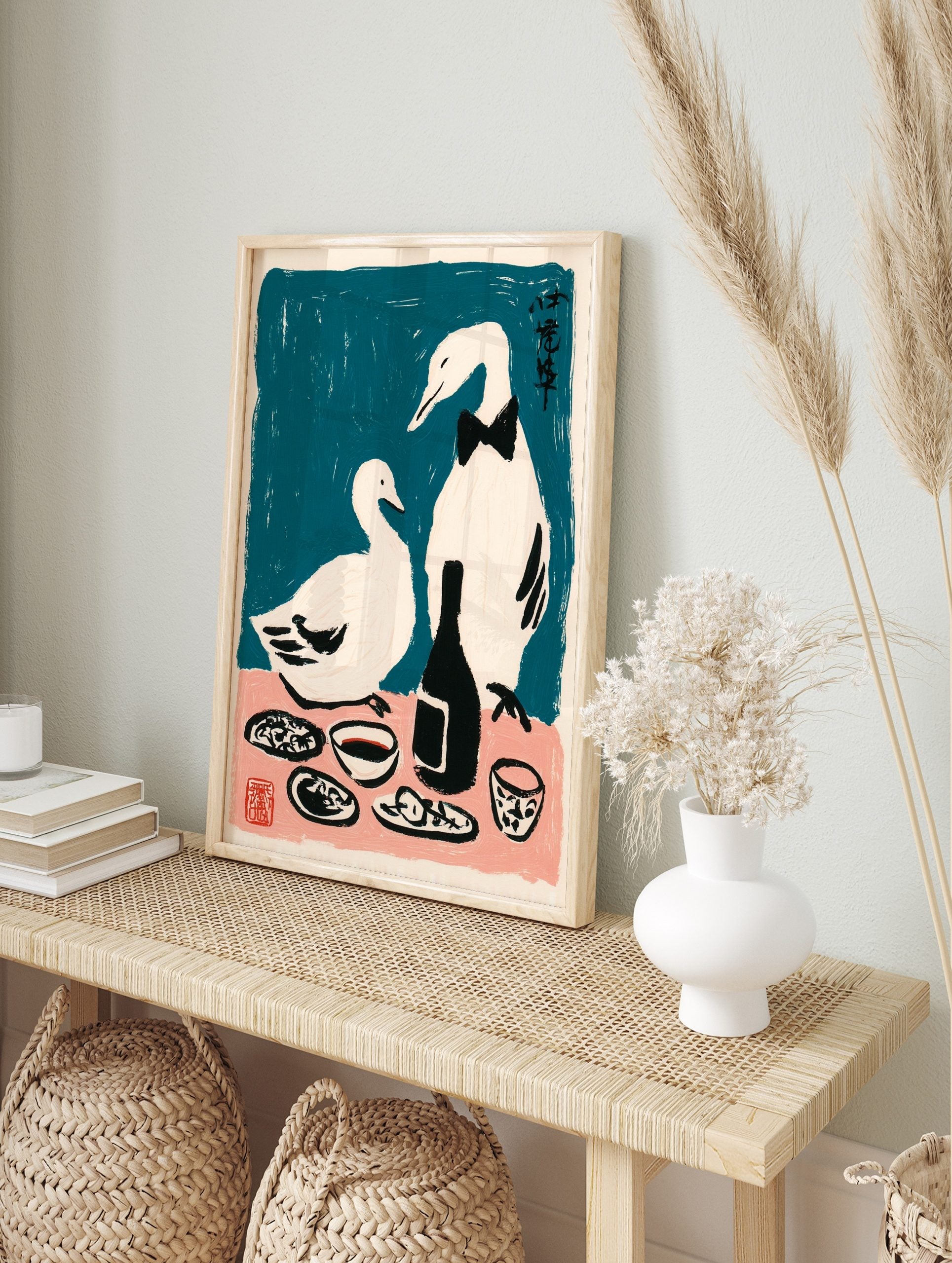 Illustrative print of two white ducks, one in a bow tie, at a dinner table with a bottle, in an alternate framed mockup