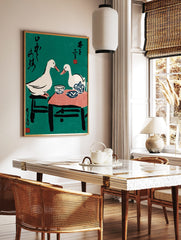 Illustrative print of two white ducks at a tea party with blue pottery, black text, and red seals, in a styled room mockup