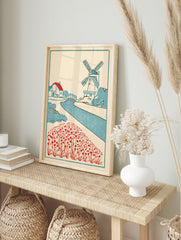 Vintage style Dutch landscape art print with a windmill, cottage, canal, and red flower field, in an alternate framed mockup