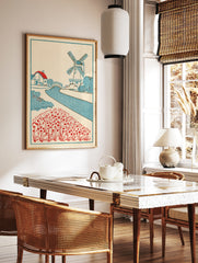 Vintage style Dutch landscape art print with a windmill, cottage, canal, and red flower field on a, in a styled room mockup