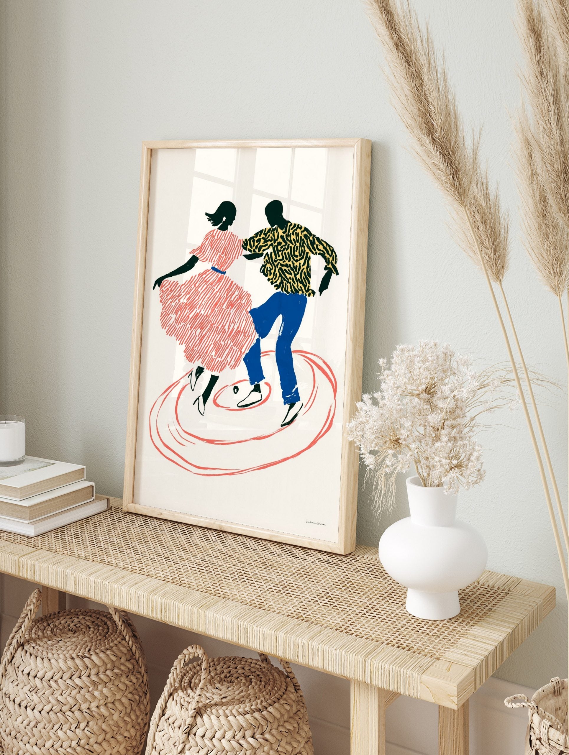 Illustrative print of two dynamic black silhouette dancers with red, blue, and yellow, in an alternate framed mockup