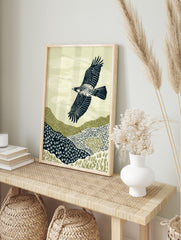 Illustrative print of an eagle with outstretched wings flying over textured green and navy, in an alternate framed mockup