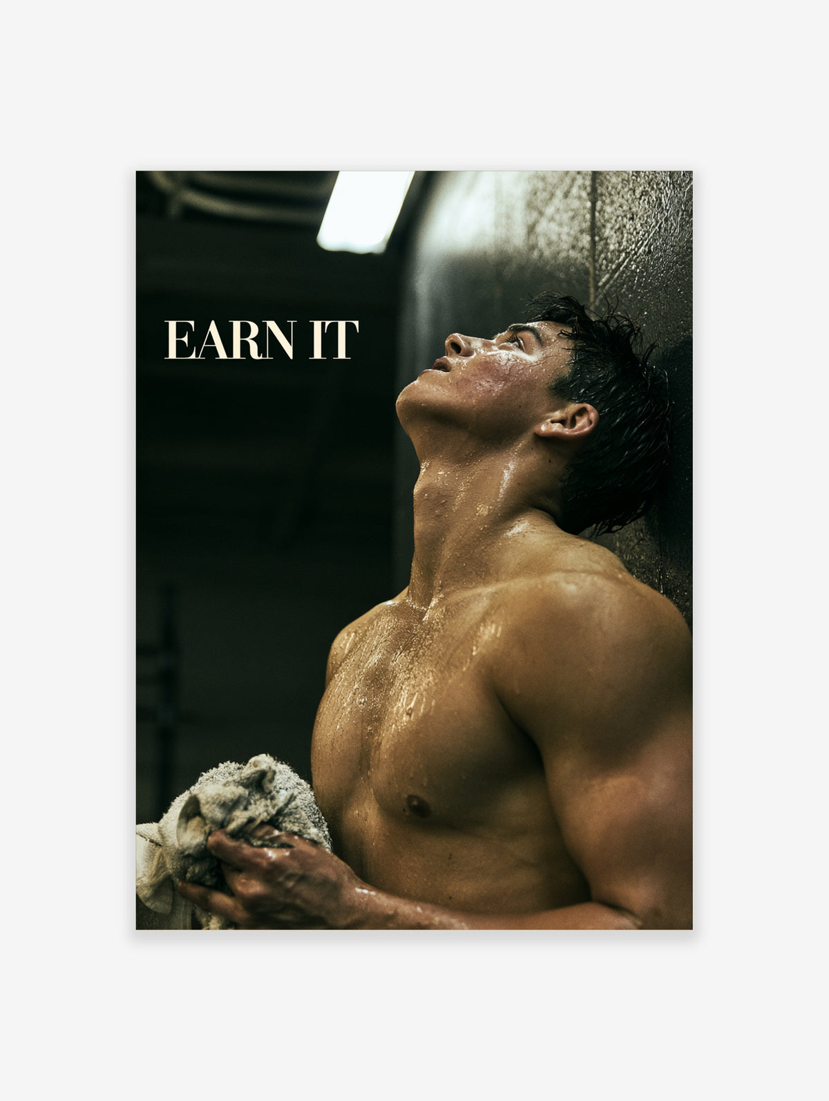 Earn It gym poster of a sweat-covered muscular man leaning against a dark wall holding a towel