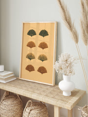 Eight stylized fan shapes in dark green and reddish-brown on a light beige background, in an alternate framed mockup