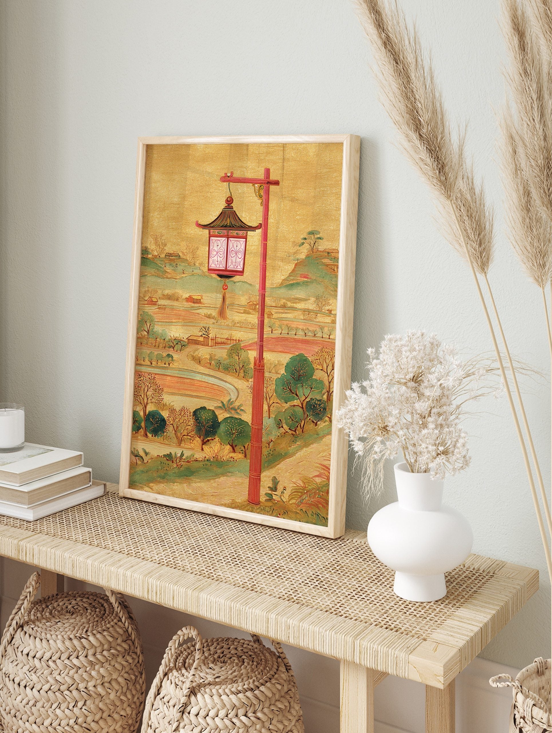 Illustrative East Asian lantern with red post, golden background, green hills, and fields, in an alternate framed mockup