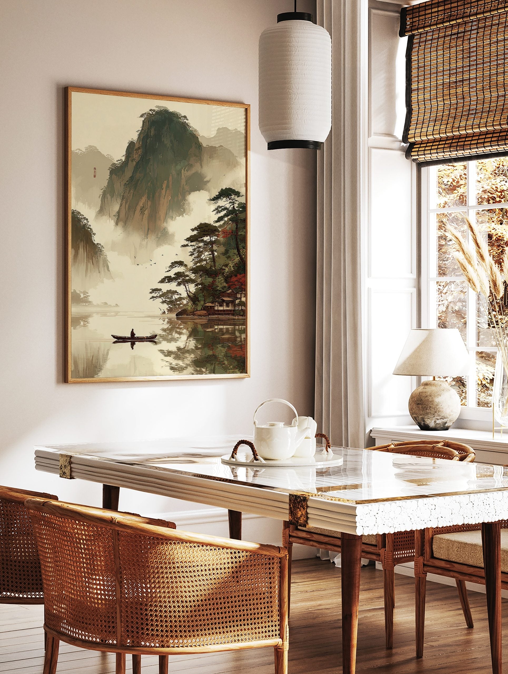 East Asian landscape art print with misty mountains, lake, person in boat, pine trees, and, in a styled room mockup