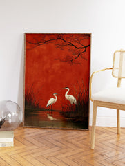 Two white egrets stand in a marsh with tall reeds and water reflections, set against a bold red background with dark tree branches. Japanese style egrets wall art. - Image 2