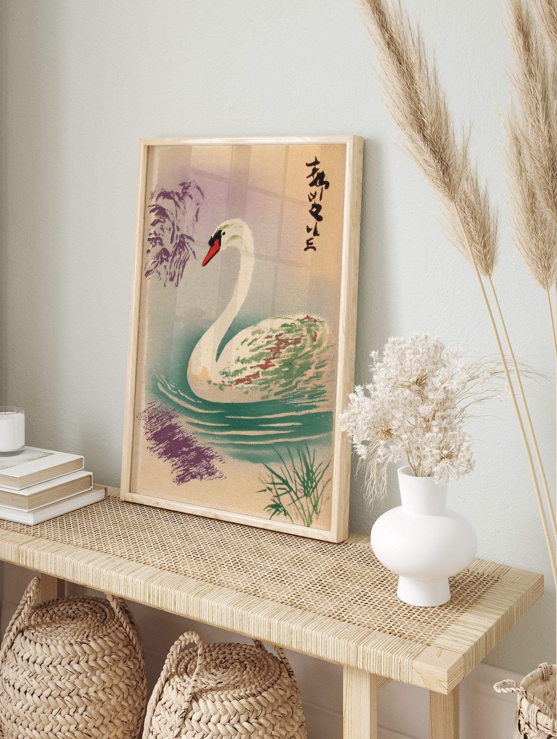 Elegant white swan with red beak swimming in water with ripples, Japanese text, and purple, in an alternate framed mockup