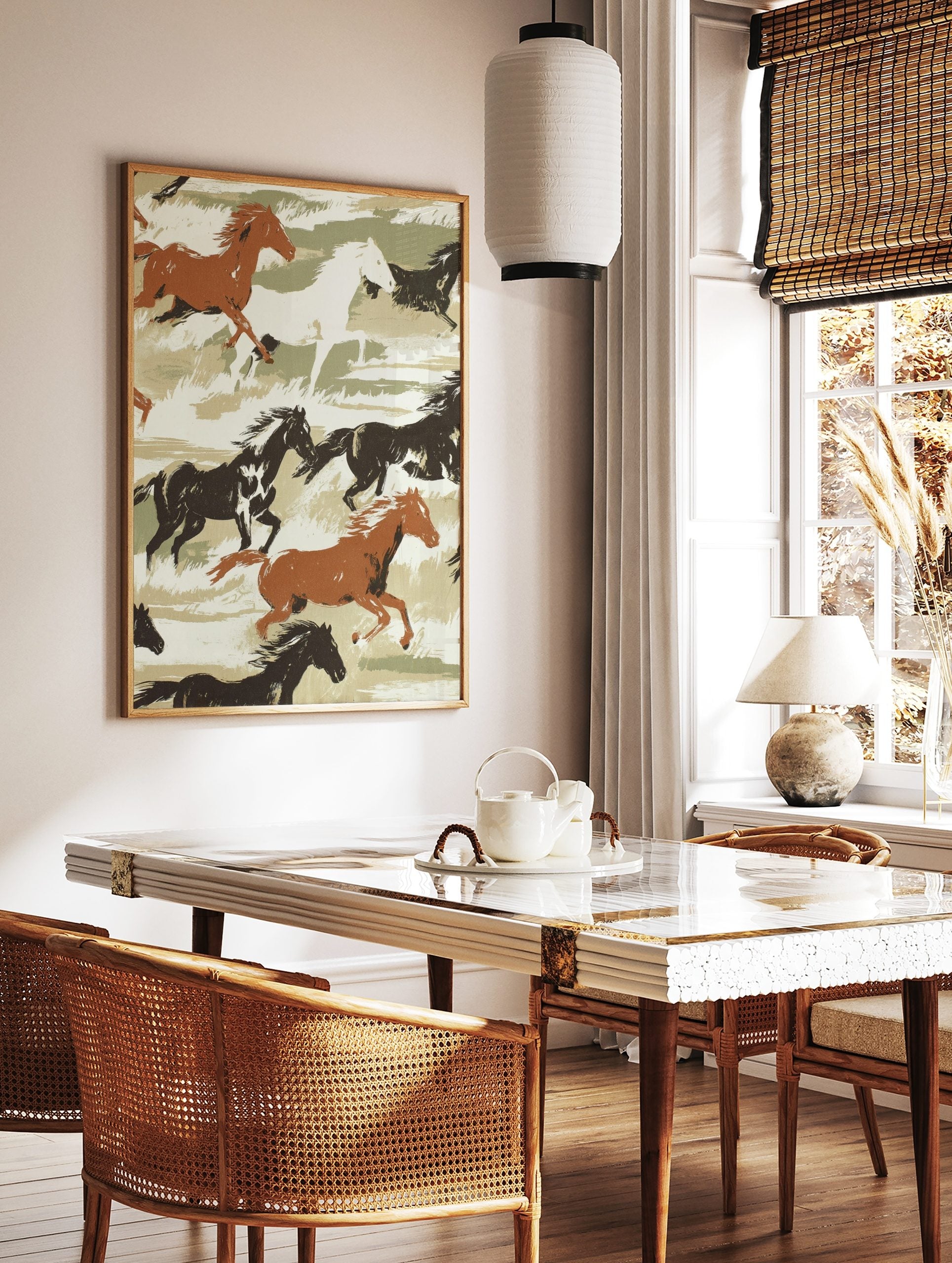 Illustrative print of galloping brown, black, and white horses on a green and beige brushstroke, in a styled room mockup