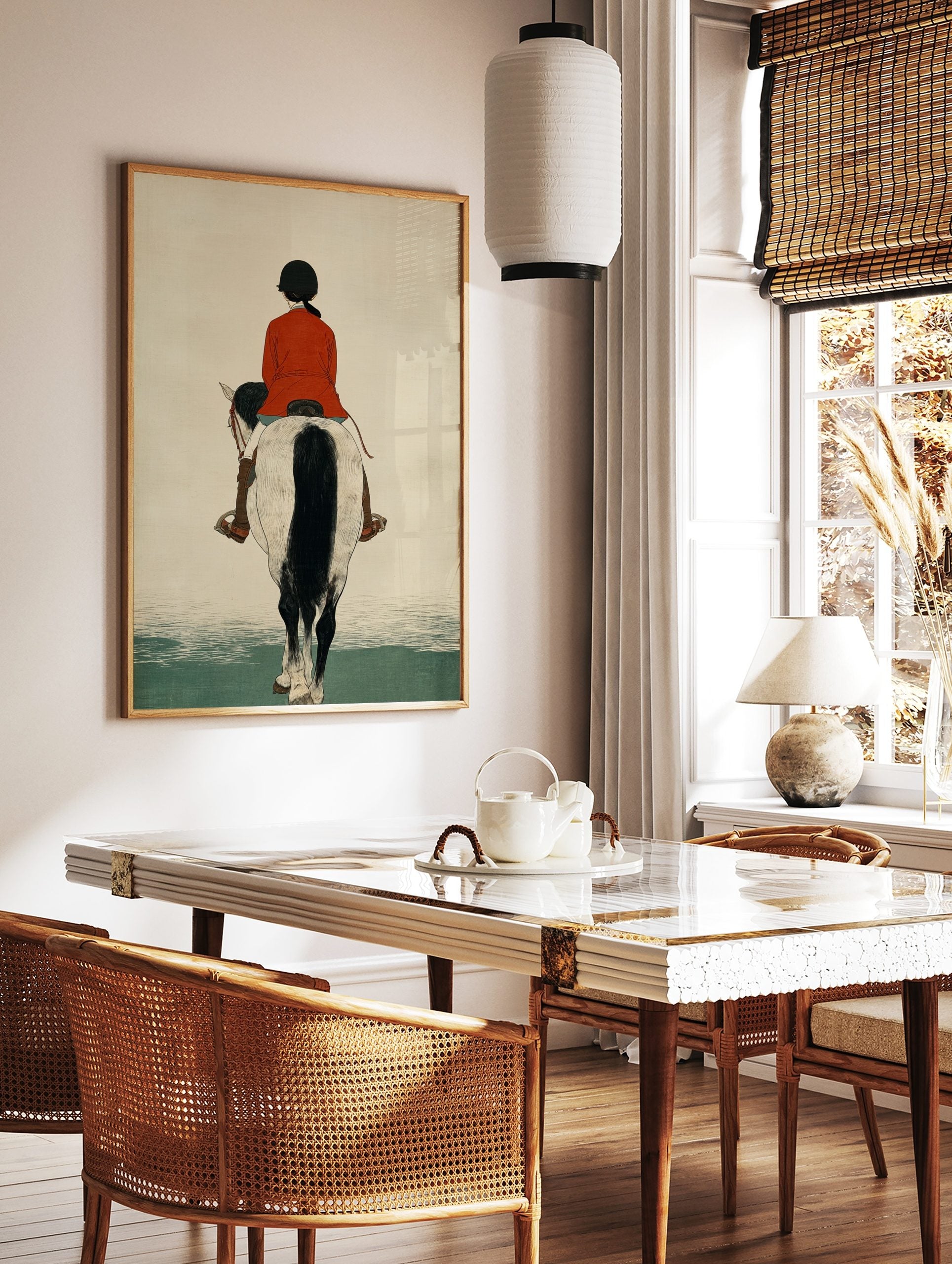 Illustrative print of a horse rider in a red jacket on a white and black horse, viewed from the back, in a styled room mockup