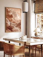 Close-up of voluminous, textured clouds in warm peach and cream tones filling the sky, in a styled room mockup