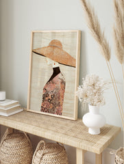 Fashion illustration of a woman in profile wearing a large, textured hat and floral patterned, in an alternate framed mockup