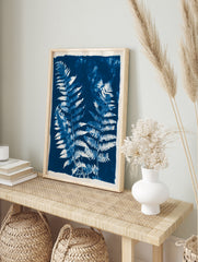Detailed fern fronds in a blue and white cyanotype style botanical wall art print, in an alternate framed mockup
