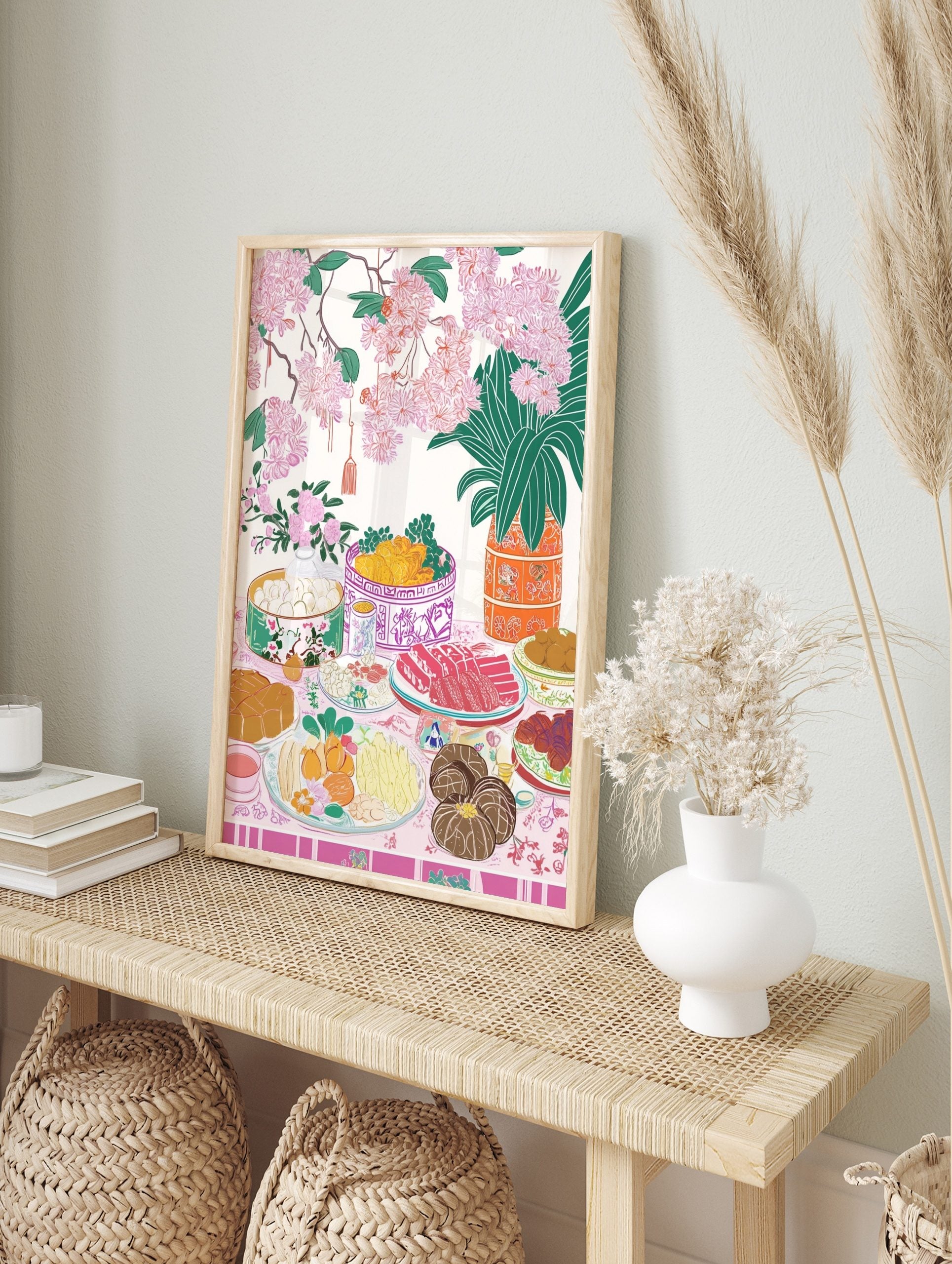 Illustrative art print of a festive table with food, pink cherry blossoms, and green foliage, in an alternate framed mockup