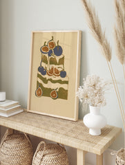 Stylized cake illustration with figs and cherries in olive green, deep blue, and cream, in an alternate framed mockup
