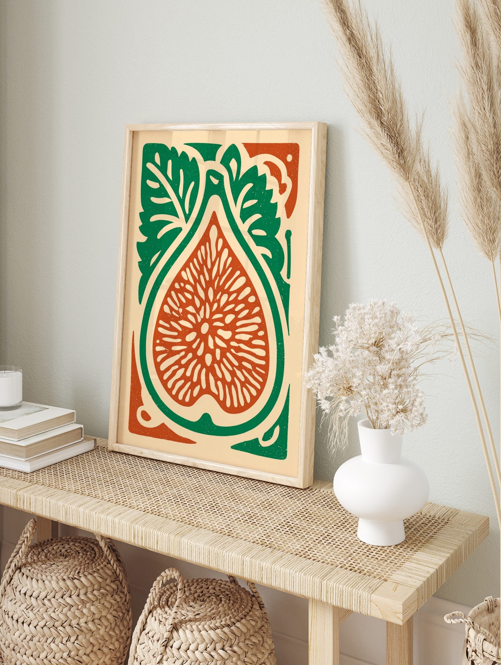 Illustrative fig botanical print, cut in half with seeds, green leaves, and reddish-orange, in an alternate framed mockup