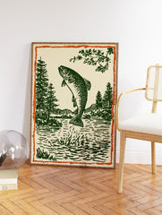 Woodcut style illustration of a jumping trout fish in a lake with pine trees and mountains, framed by an orange border. - Image 2