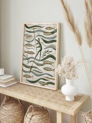 Stylised folk art painting of a person poling through water with fish and green plants in, in an alternate framed mockup