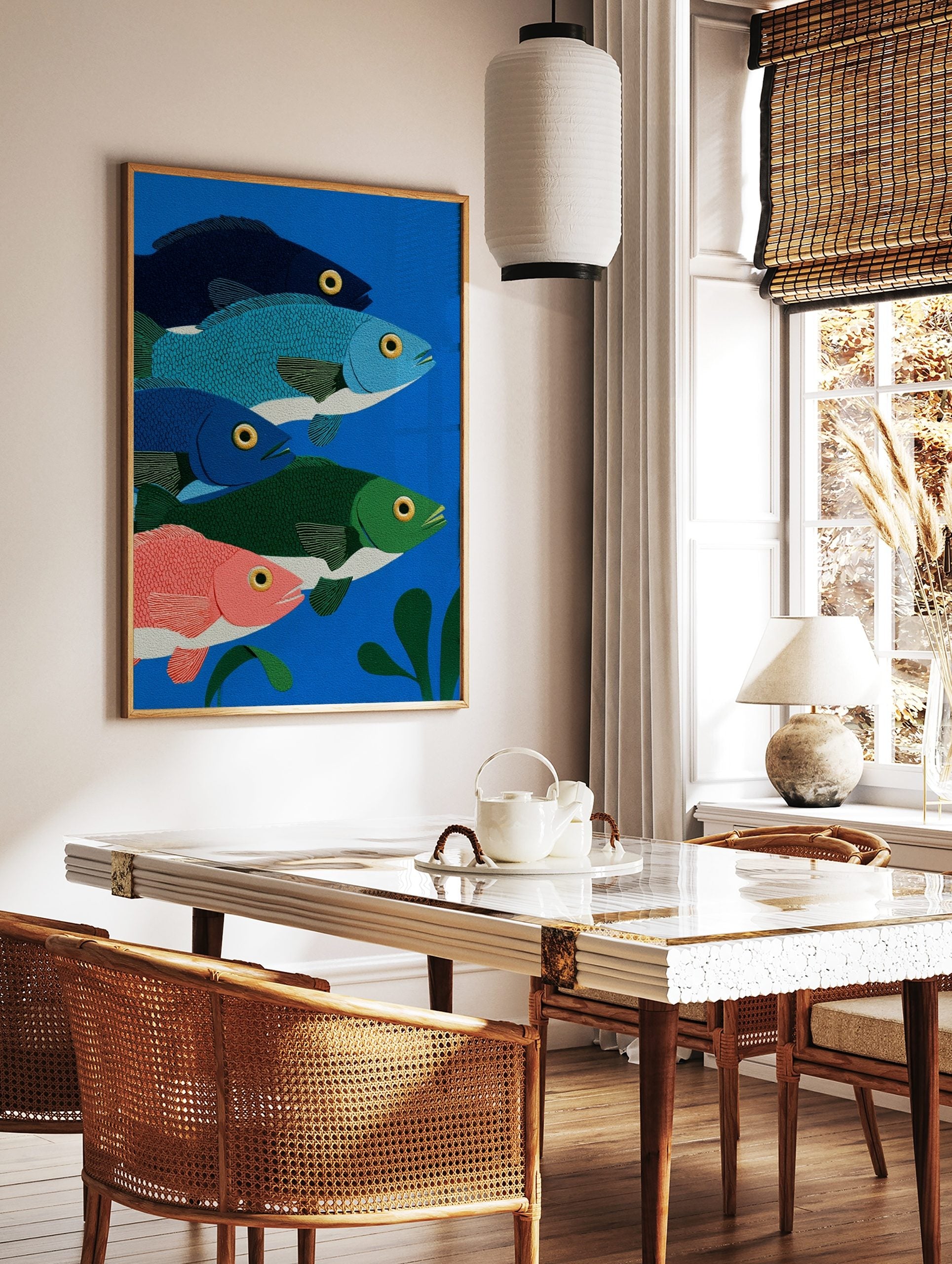 Illustrative print of five colourful fish in blue, green, and pink, swimming in deep blue water, in a styled room mockup