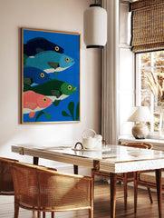 Illustrative print of five colourful fish in blue, green, and pink, swimming in deep blue water, in a styled room mockup