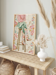 Illustrative print of a person's legs wearing colourful floral cowboy boots, sitting on a, in an alternate framed mockup
