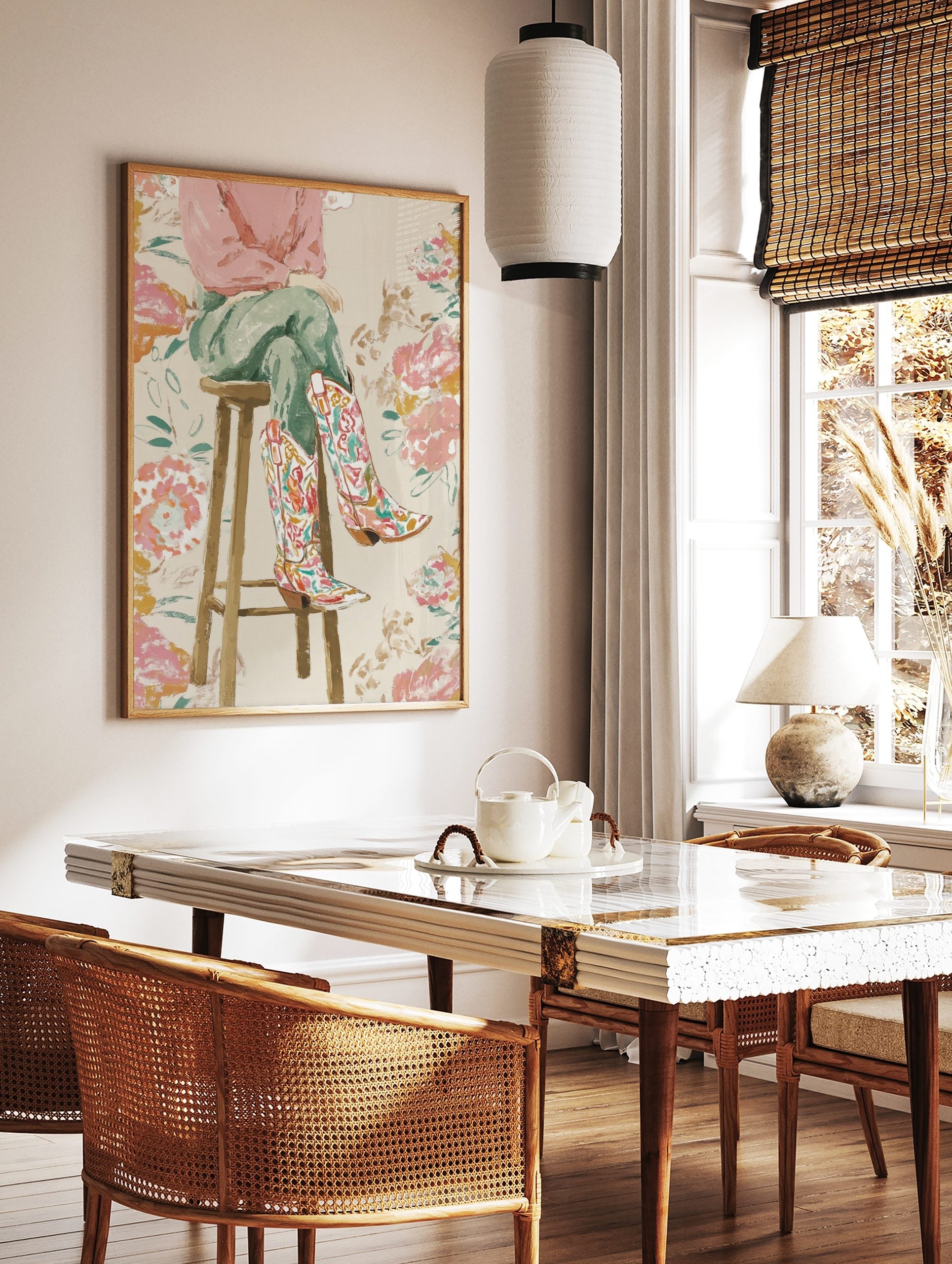 Illustrative print of a person's legs wearing colourful floral cowboy boots, sitting on a wooden, in a styled room mockup