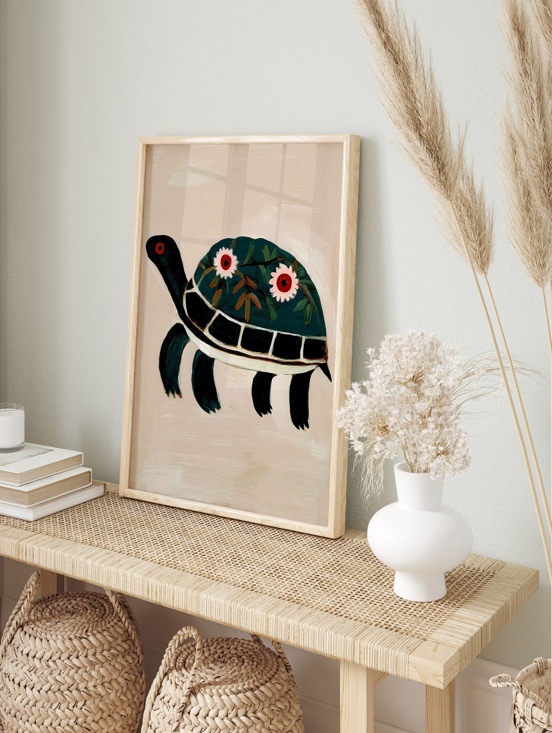 Illustrative dark green turtle wall art print with floral decorated shell and red eyes on, in an alternate framed mockup