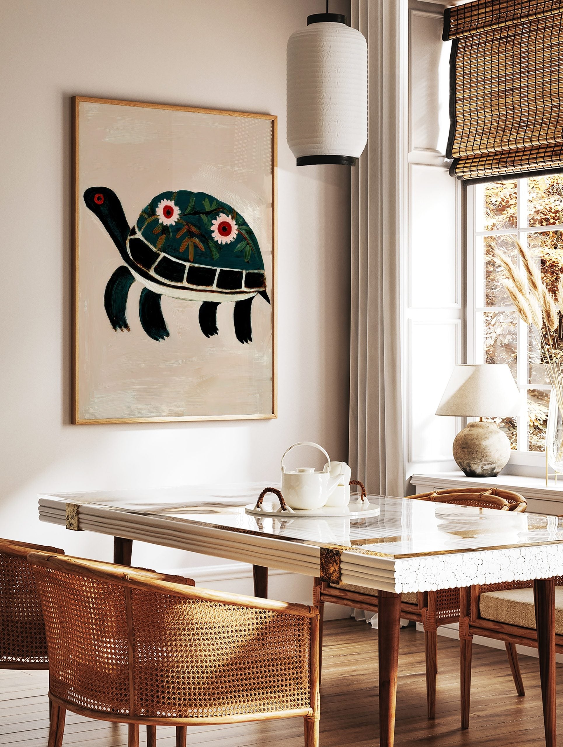 Illustrative dark green turtle wall art print with floral decorated shell and red eyes on beige, in a styled room mockup