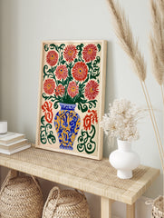 Illustrative red chrysanthemum flowers in a blue and yellow vase with green swirls on a cream, in an alternate framed mockup