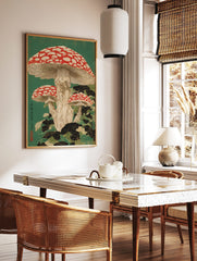 Japanese woodblock print of three red and white spotted fly agaric mushrooms with dark green leaves, in a styled room mockup