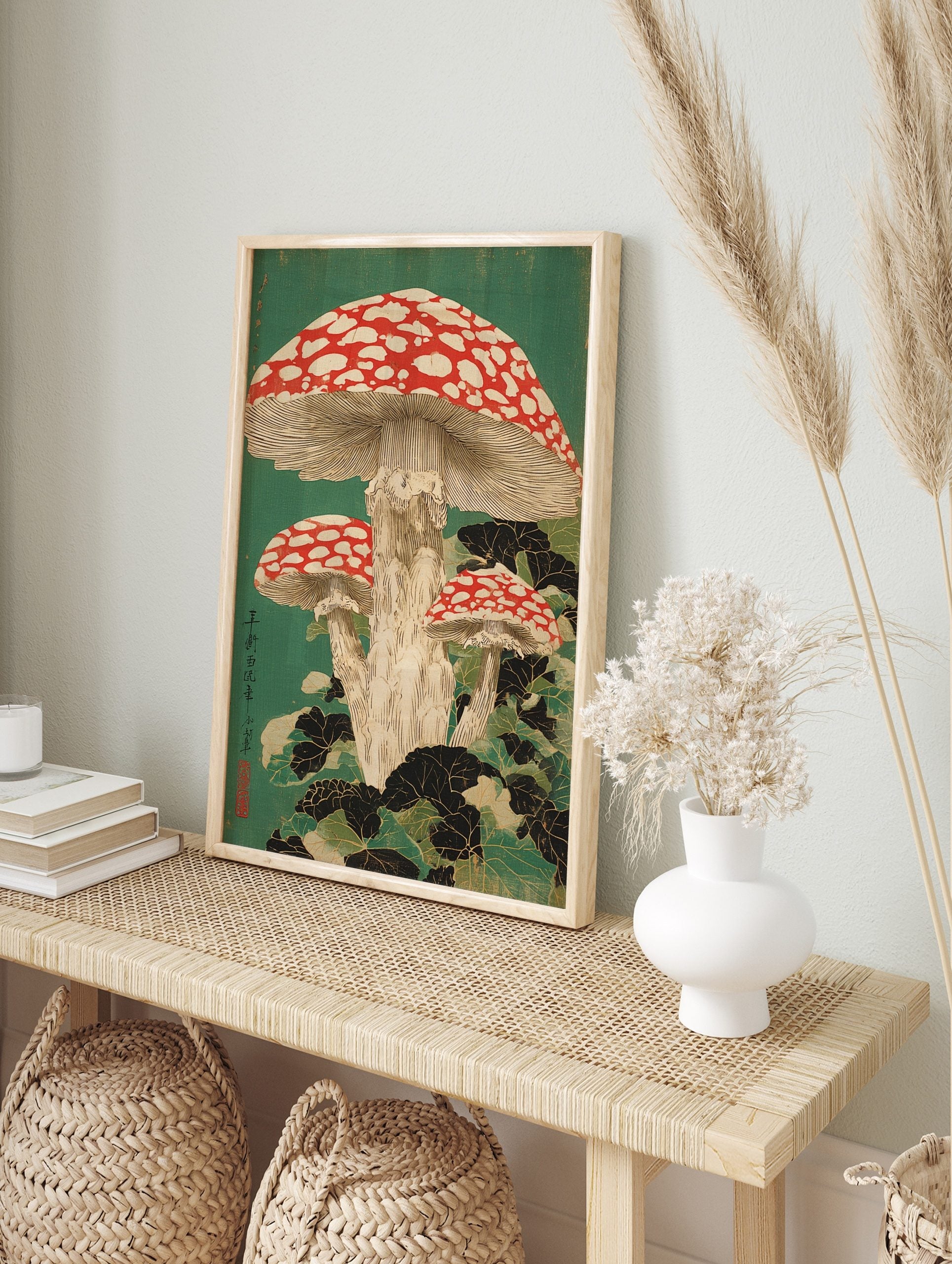 Japanese woodblock print of three red and white fly agaric mushrooms with dark foliage on a, in an alternate framed mockup