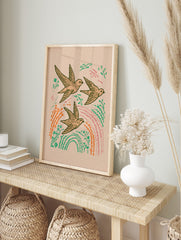 Illustrative print of three flying swallows with green leaves, orange plants, and pink, in an alternate framed mockup