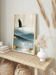A crane in flight over abstract blue hills with golden accents, an artistic wall art print on, in an alternate framed mockup