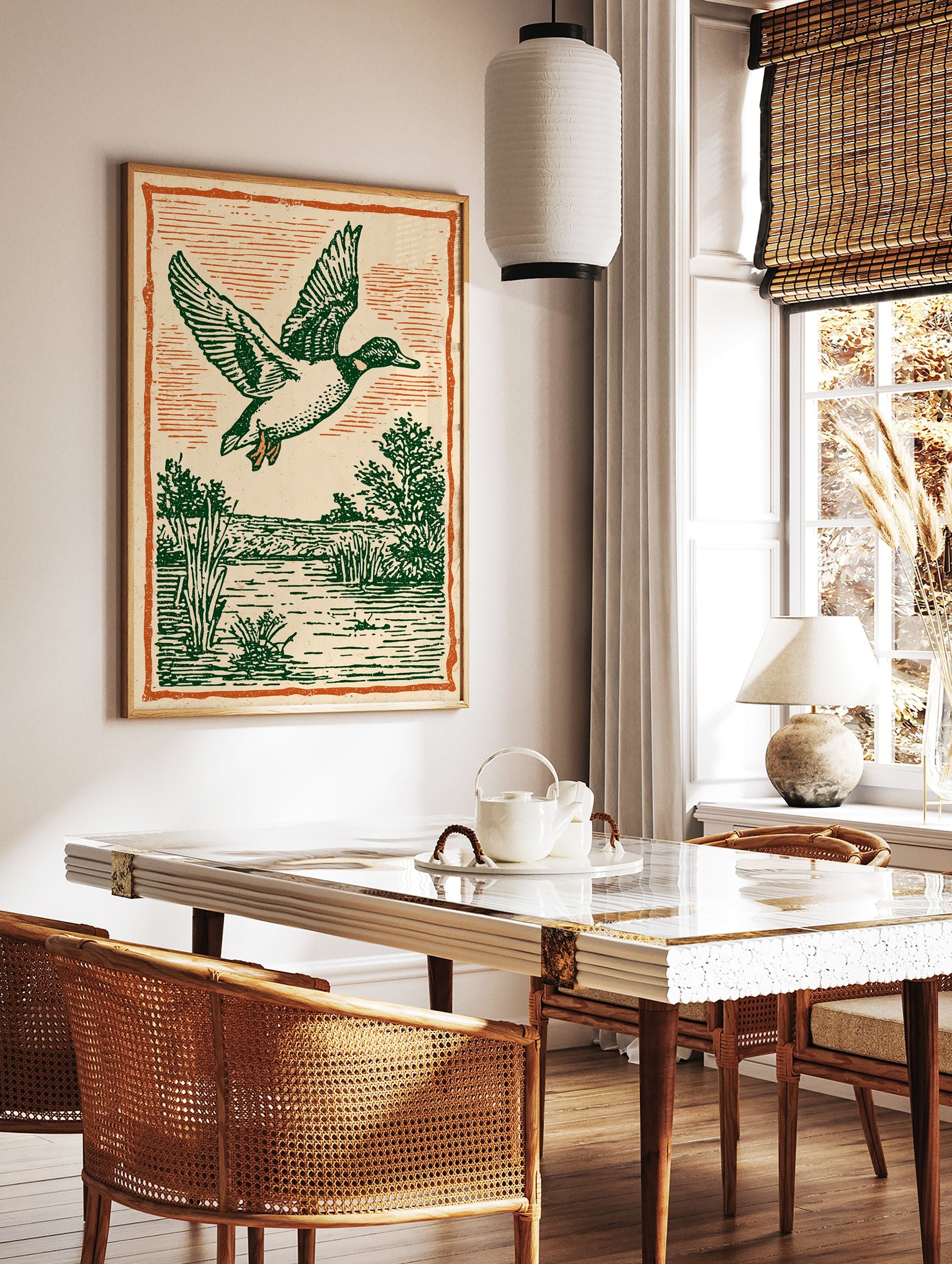 Vintage illustration of a flying duck with green feathers over a marsh and water, framed by an orange border. - Image 3