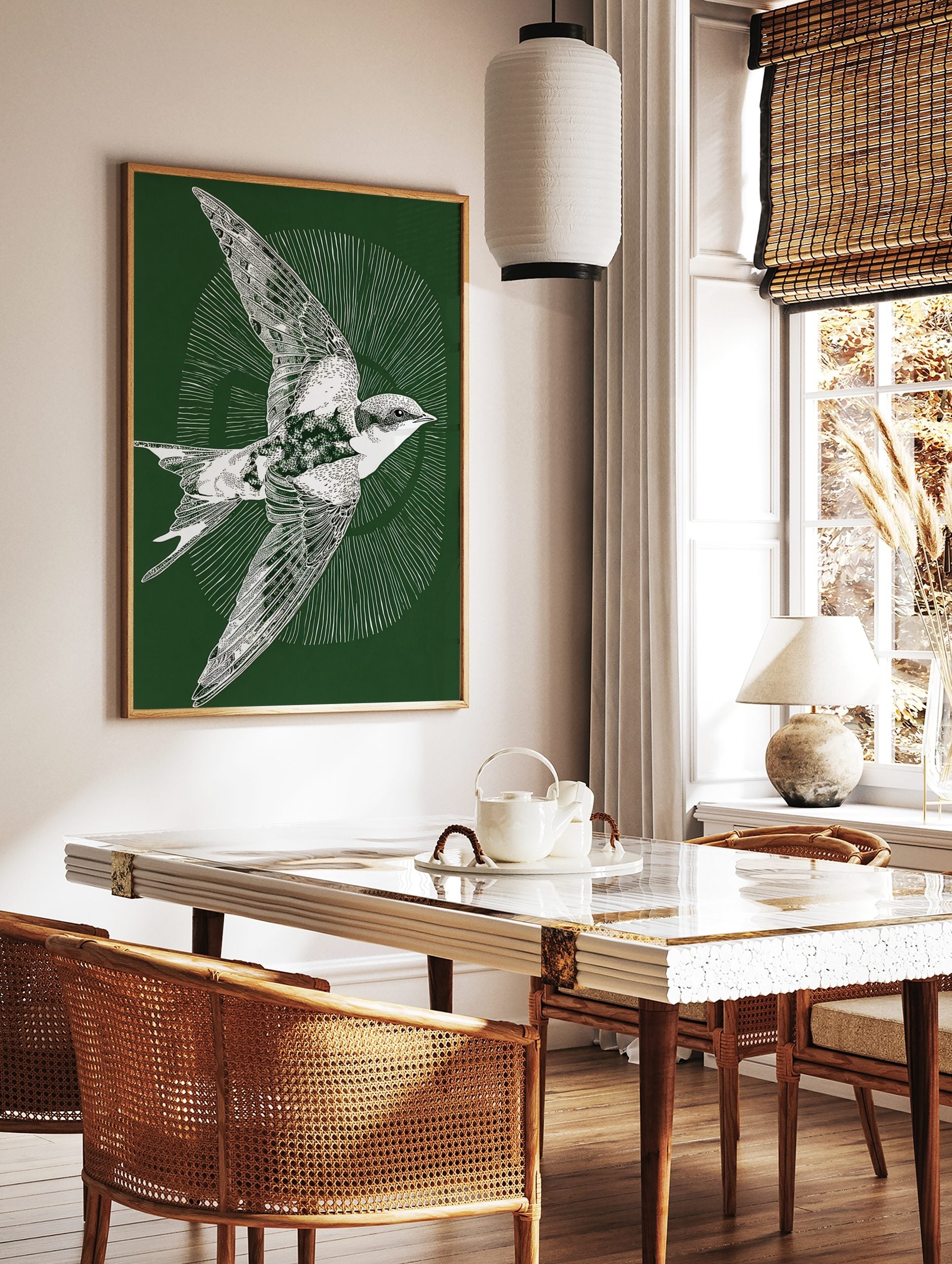 White illustrative swallow bird in flight on a dark green background with radiating lines, in a styled room mockup