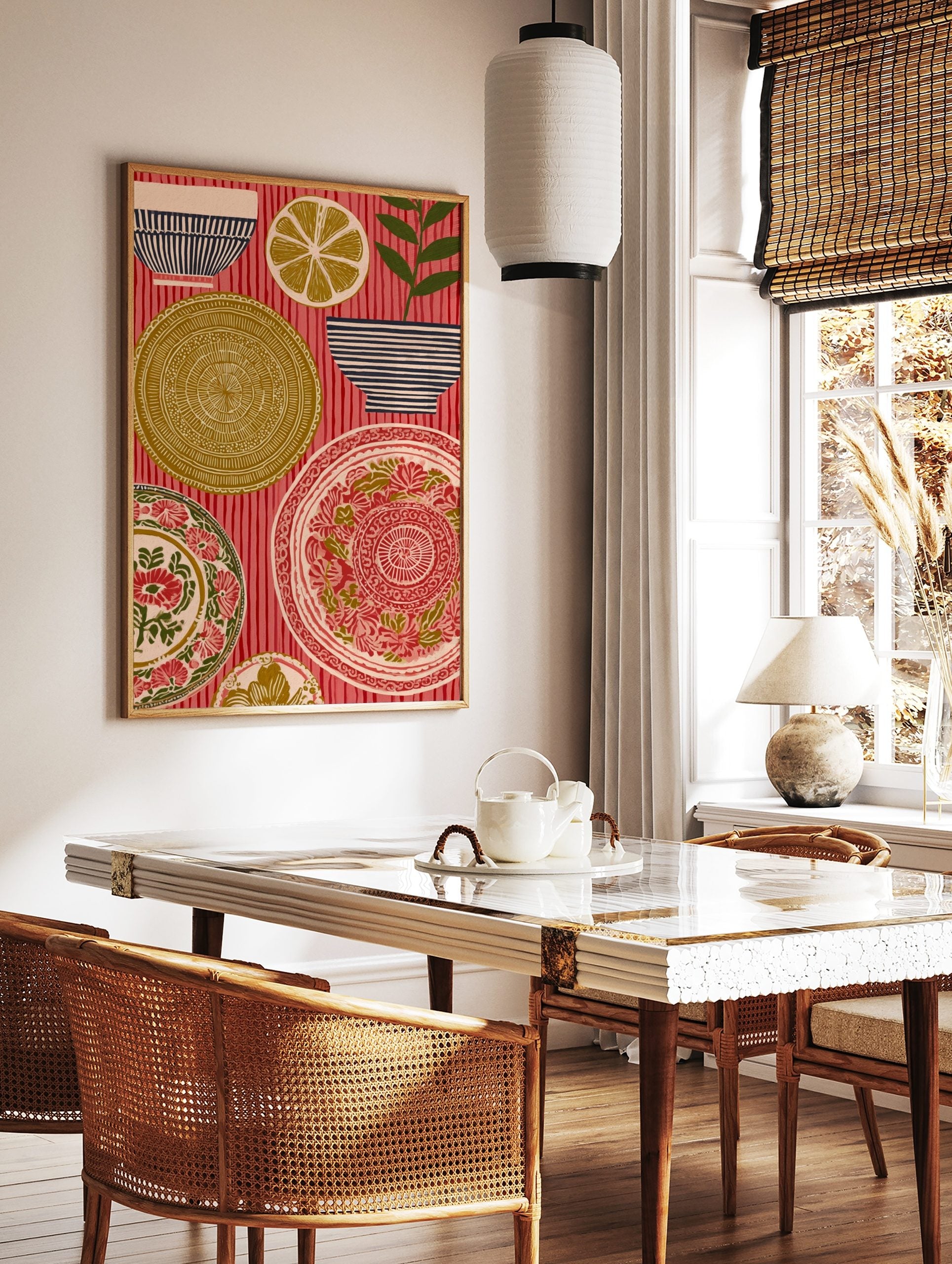Folk art print of ornate plates, striped bowls, a lemon slice, and a plant on a red striped, in a styled room mockup