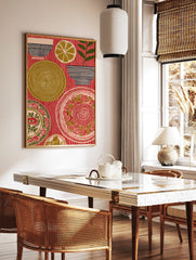 Folk art print of ornate plates, striped bowls, a lemon slice, and a plant on a red striped, in a styled room mockup