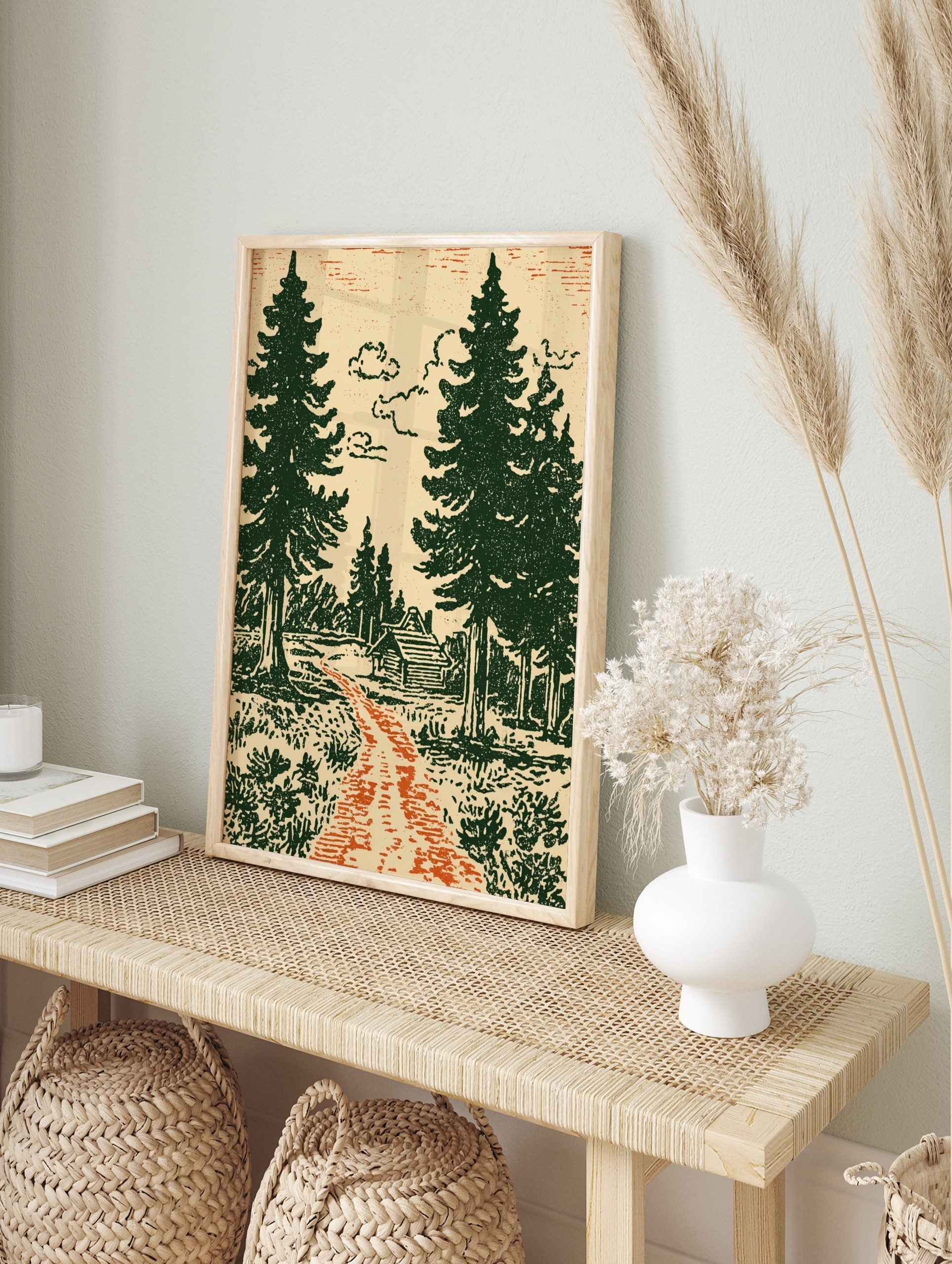 Illustrative forest scene with a log cabin, green pine trees, orange path, and cream sky, in an alternate framed mockup