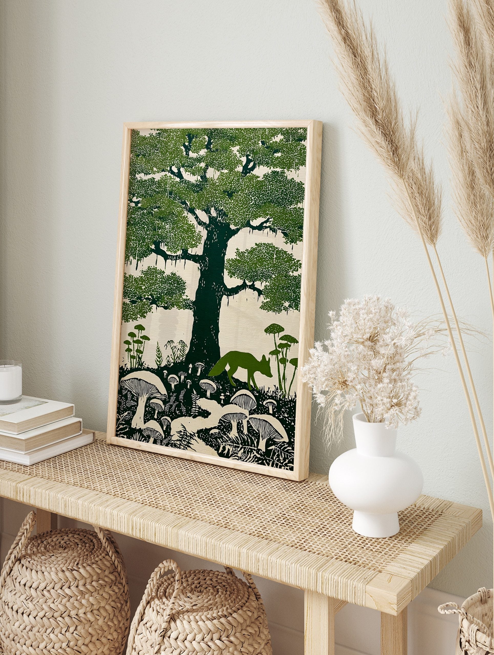 Linocut style art print of a green fox walking under a large oak tree with moss and mushrooms, in an alternate framed mockup