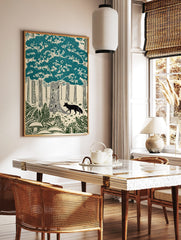 Woodcut style forest print with a black fox, teal trees, ferns, and mushrooms on a cream background, in a styled room mockup