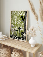 Linocut-style forest art print with black squirrel, green trees, and white mushrooms on a, in an alternate framed mockup