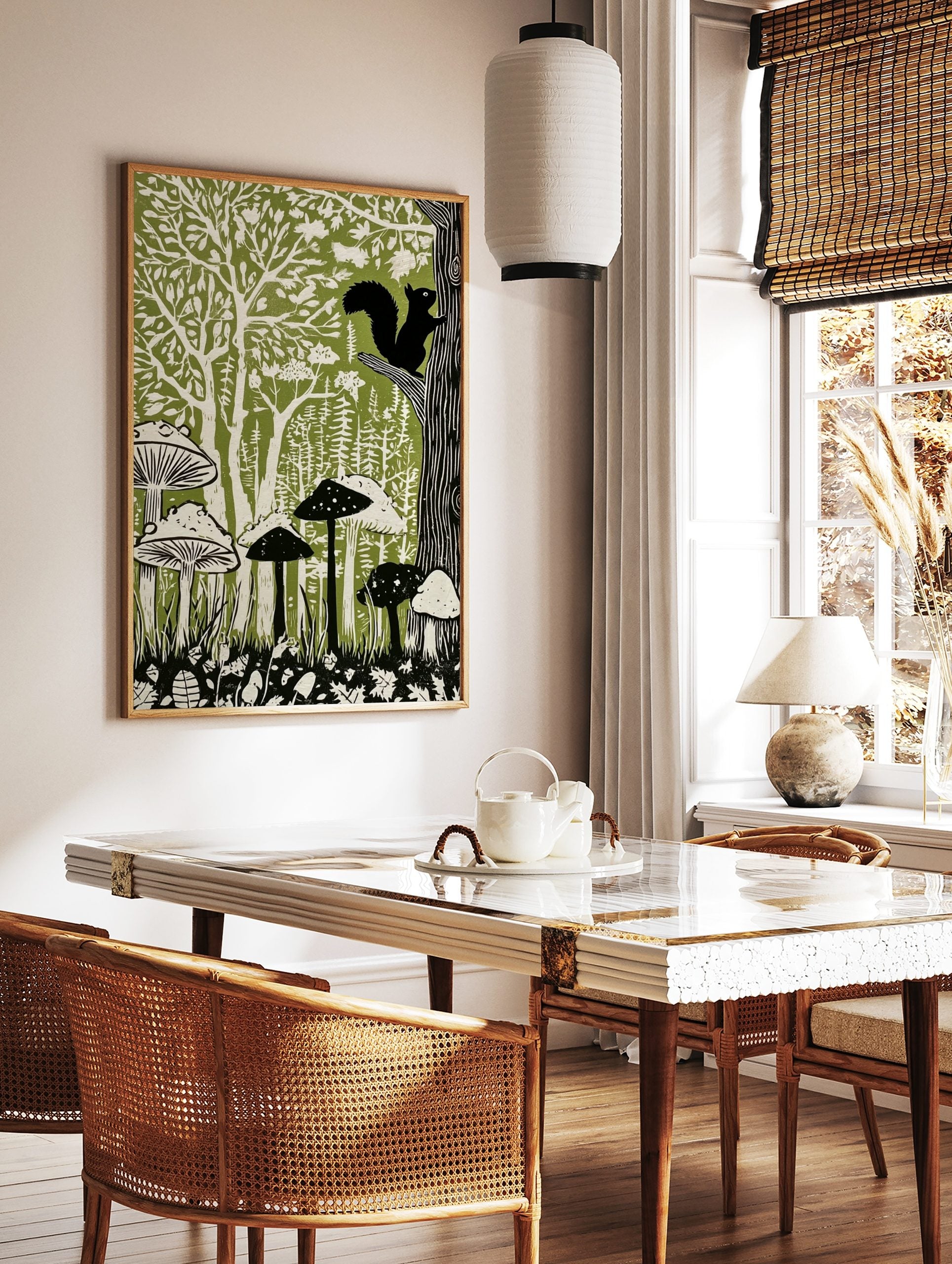 Linocut-style forest art print with black squirrel, green trees, and white mushrooms on a green, in a styled room mockup