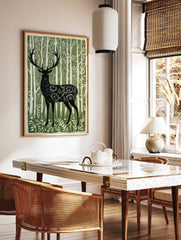 Illustrative green and white print of a forest stag with ornate body patterns amidst tall trees, in a styled room mockup