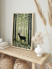 Green woodcut print of a stag with antlers in a dense forest with ferns and tall trees, in an alternate framed mockup
