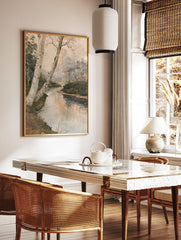 Watercolor style forest landscape painting with a winding stream and birch trees in the foreground, in a styled room mockup