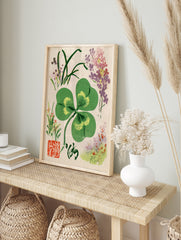 Four-leaf clover botanical illustration with corner flowers, calligraphy, and red seal on, in an alternate framed mockup