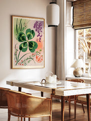 Four-leaf clover botanical illustration with Japanese calligraphy and red seal on pink and lavender, in a styled room mockup