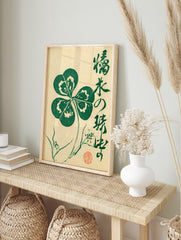 Four-leaf clover botanical illustration with Japanese calligraphy and red seal on cream paper, in an alternate framed mockup