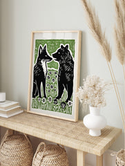 Stylised black fox and bear illustration facing each other in green and white flower field, in an alternate framed mockup